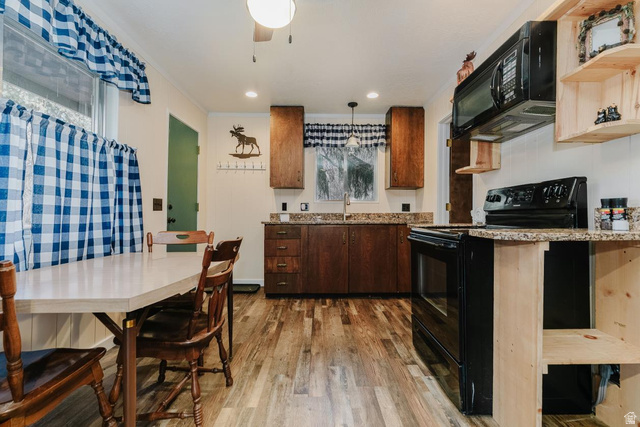 1105 Litz Road Preston, ID 83263 - Photo 8 of 24 Kitchen with black appliances, light stone counters, wood-type flooring, pendant lighting, and open shelves