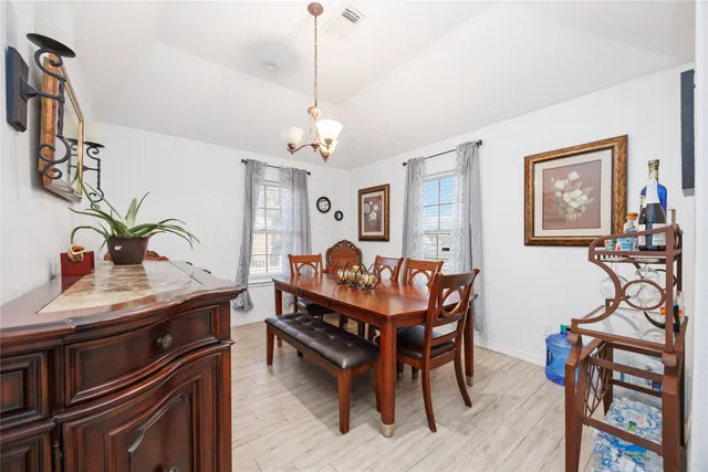 a room with chandelier fan and wooden floor