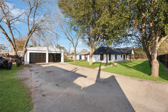 a view of an house with backyard and a tree