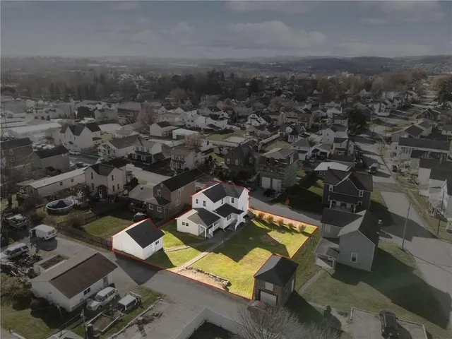 an aerial view of residential houses with yard