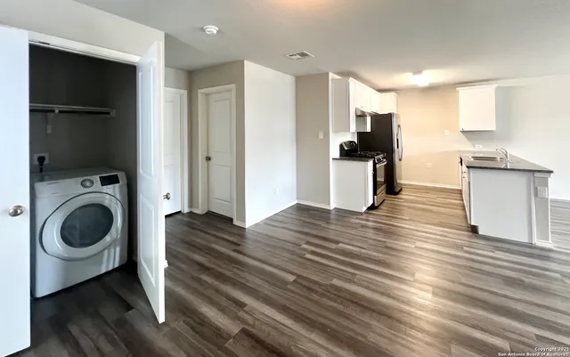 a view of a kitchen with a sink a refrigerator and window