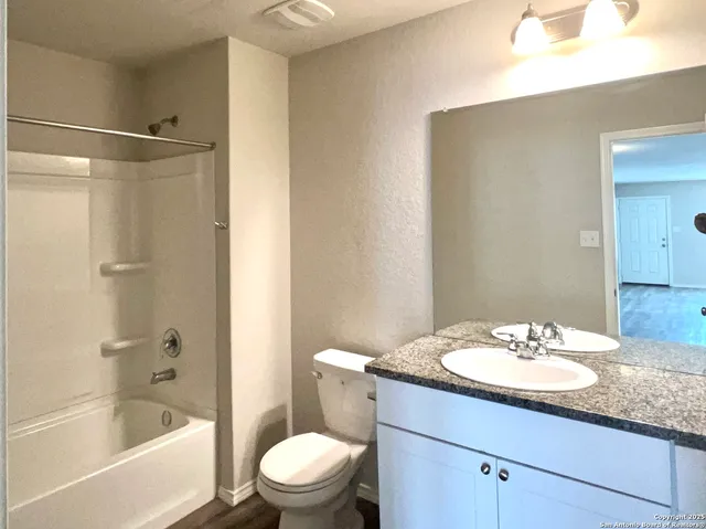 a bathroom with a granite countertop sink toilet and shower