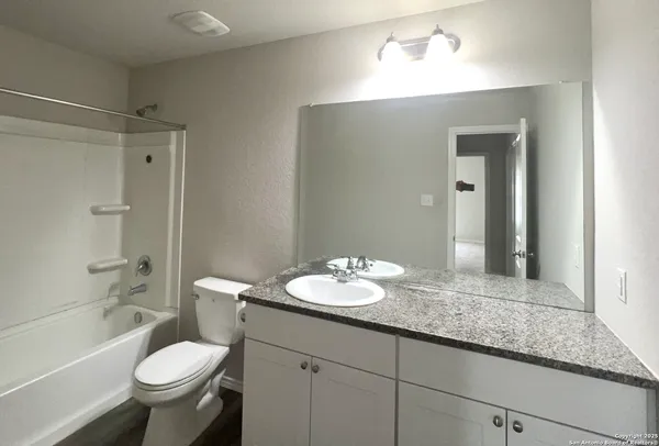 a bathroom with a granite countertop sink toilet and shower