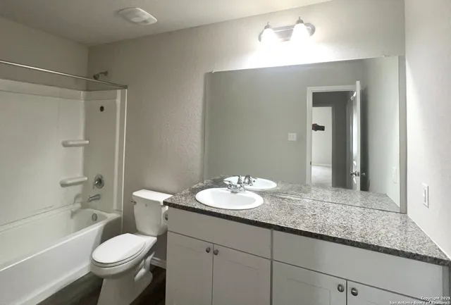a bathroom with a granite countertop sink toilet and shower