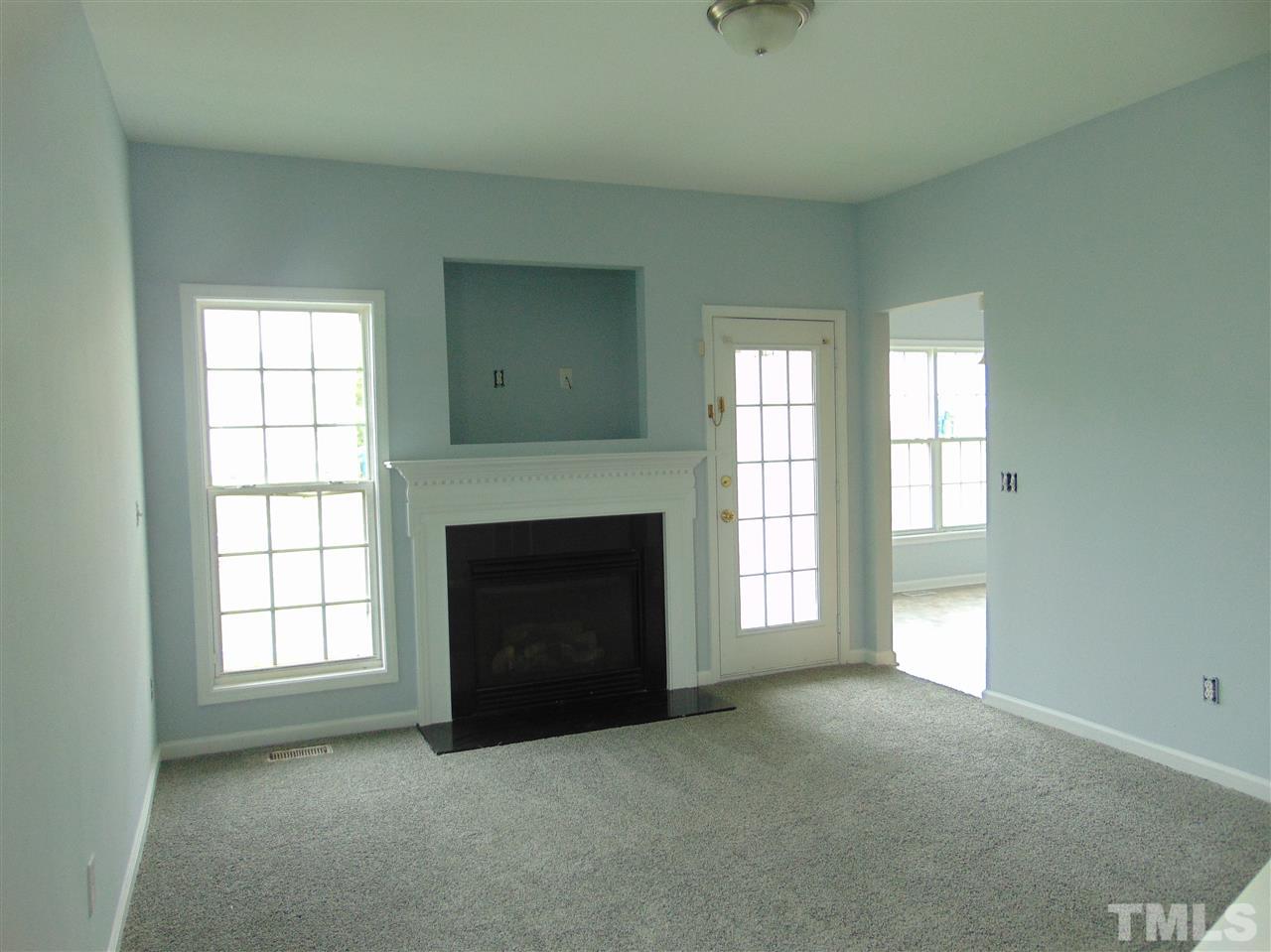 3828 Pin Oak Road Raleigh, NC 27604 - Photo 7 of 10 an empty room with windows and fireplace