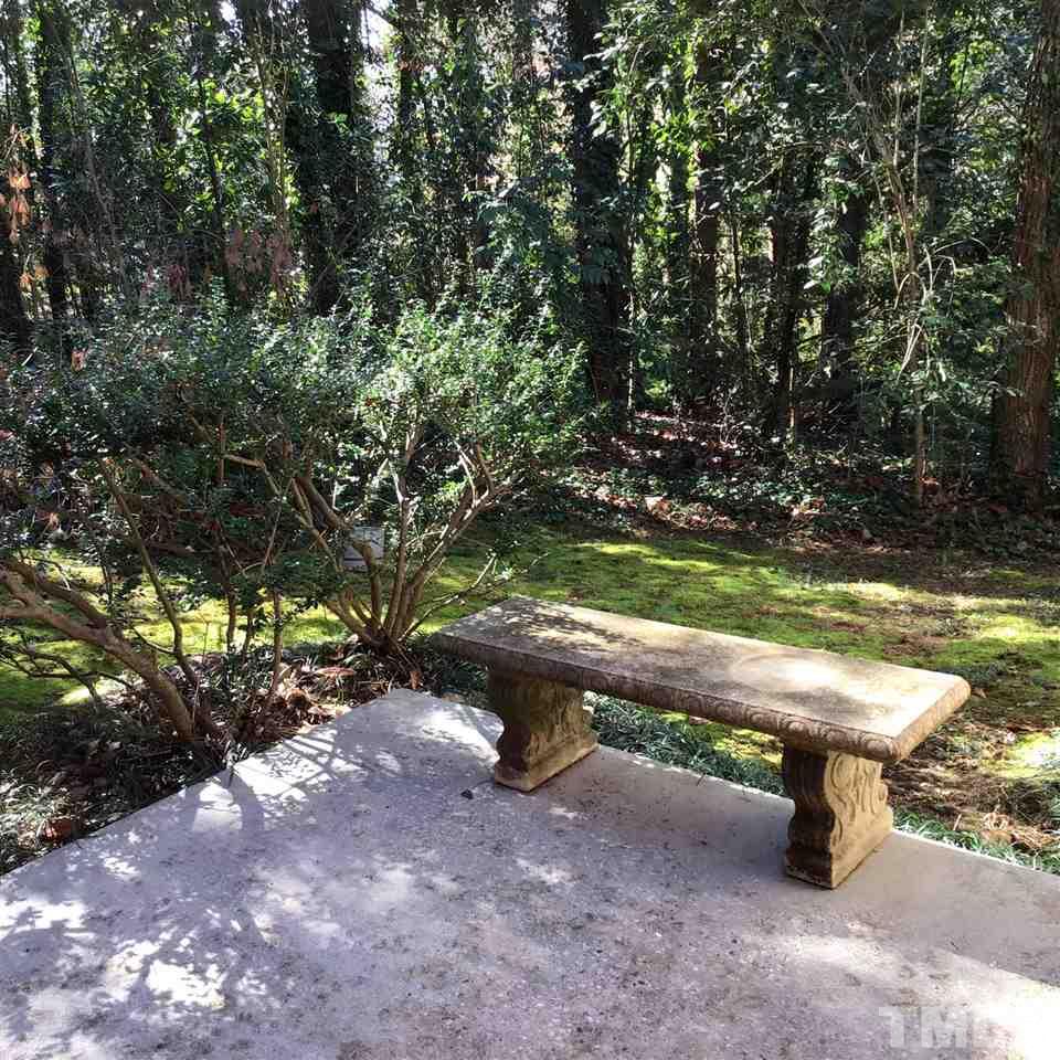 3701 Pembrook Place Raleigh, NC 27612 - Photo 26 of 30 a wooden bench sitting in the middle of a forest