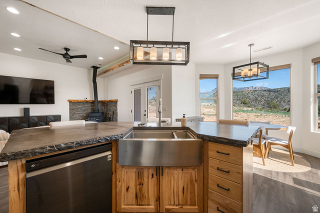 62 North Lucky 7 Road Veyo, UT 84782 - Photo 43 of 43 Kitchen featuring dishwashing machine, light wood finished floors, a wood stove, open floor plan, and wood finish cabinetry