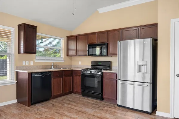 a kitchen with stainless steel appliances granite countertop a refrigerator stove a sink dishwasher and a refrigerator