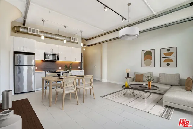 a living room with stainless steel appliances furniture a dining table and a fireplace