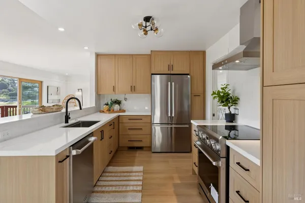 a kitchen with stainless steel appliances a sink and a refrigerator