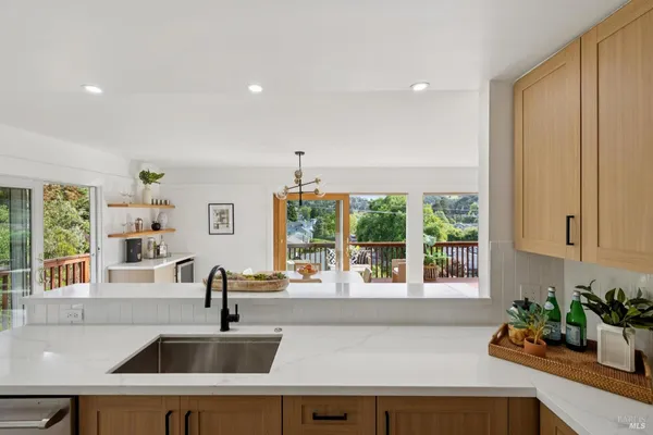 a kitchen with a sink a counter top space and living room area