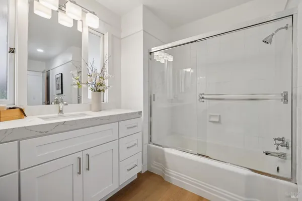 a bathroom with a shower sink vanity and mirror