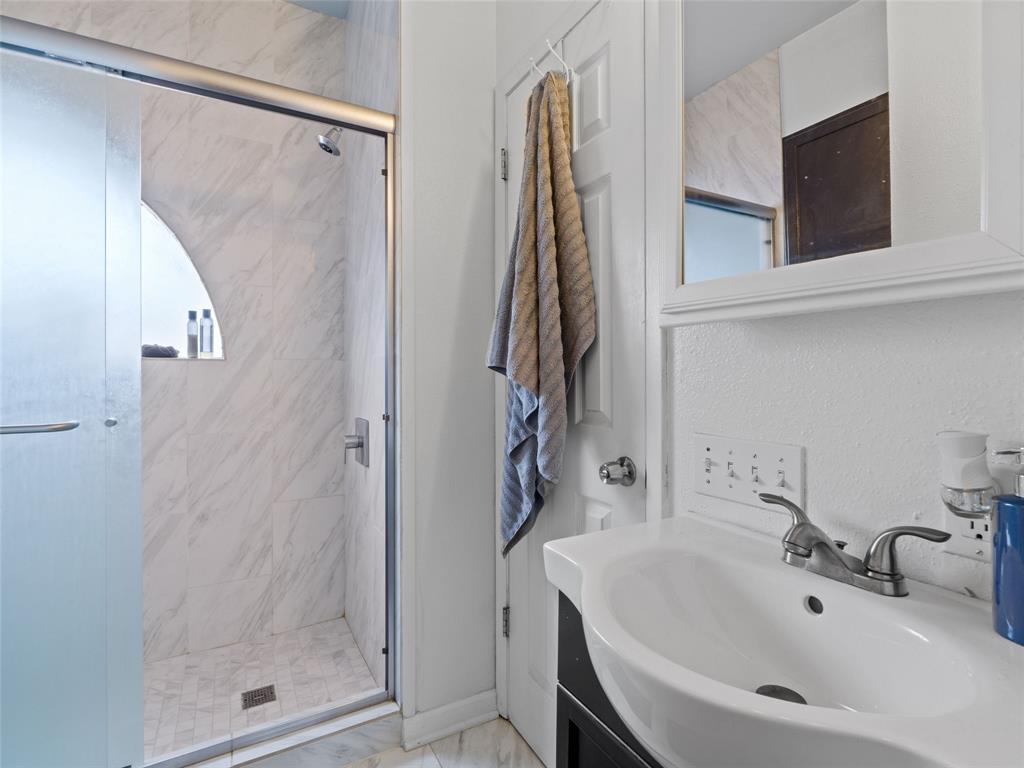 2801 Rio Grande Street, Unit 205 Austin, TX 78705 - Photo 15 of 25 a bathroom with a sink a mirror and shower