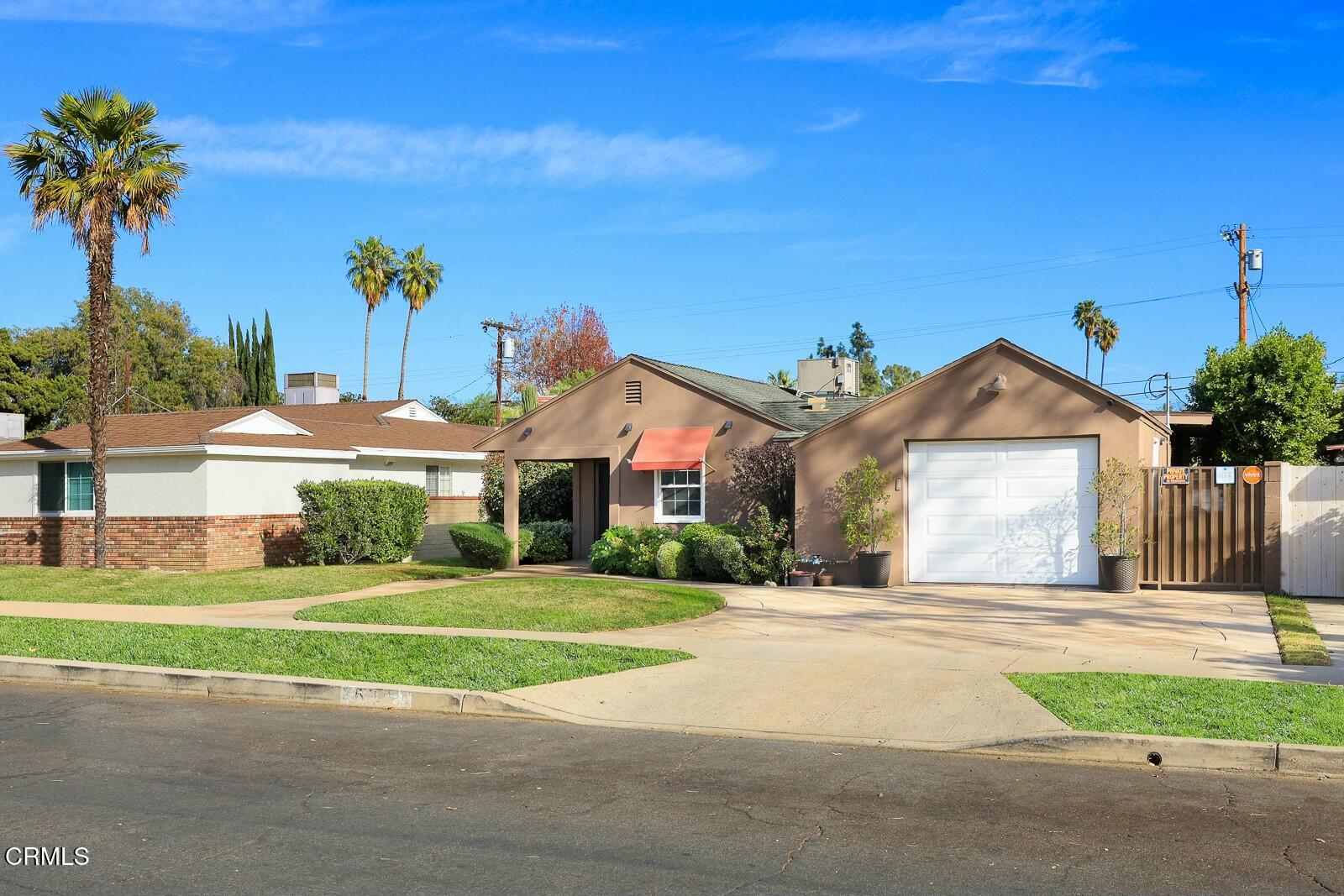 6708 Ranchito Avenue Van Nuys, CA 91405 - Photo 37 of 37 a front view of a house with a yard and potted plants