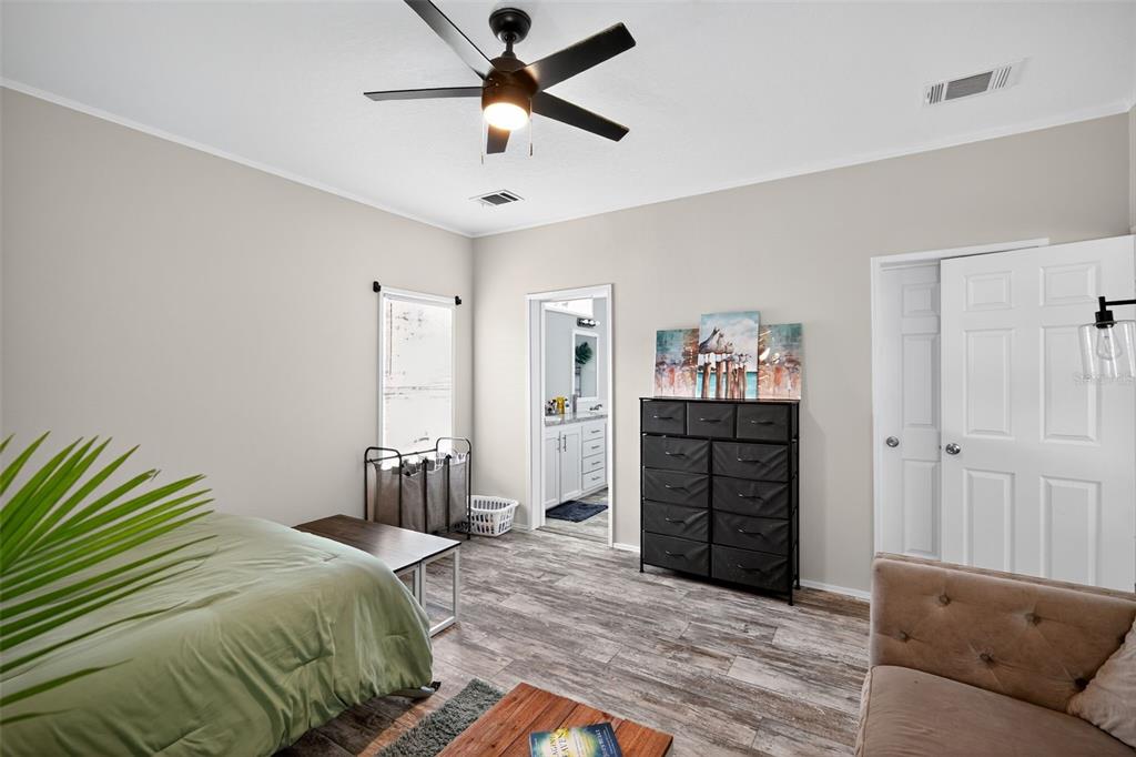12706 McIntosh Road Plant City, FL 33565 - Photo 15 of 30 a bedroom with a bed and a chandelier