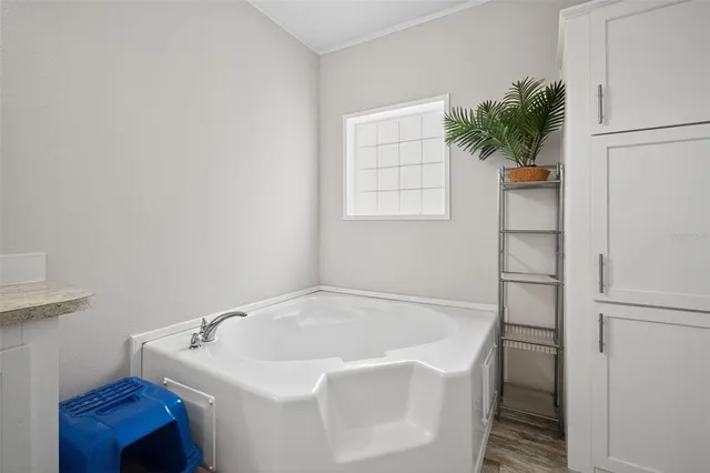 a white bath tub sitting next to a white cabinet