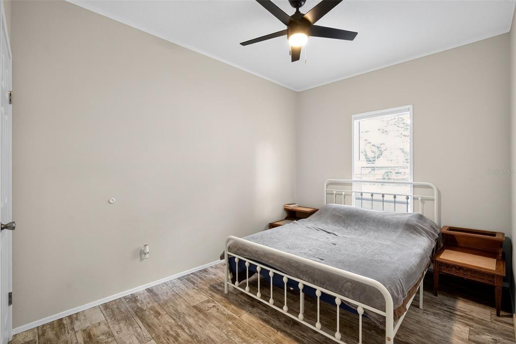 12706 McIntosh Road Plant City, FL 33565 - Photo 19 of 30 a bedroom with a bed and a chandelier