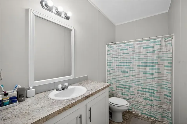 a bathroom with a granite countertop toilet sink and mirror