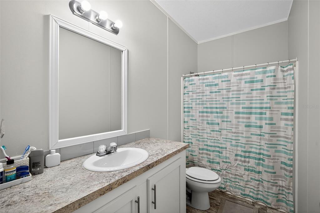 12706 McIntosh Road Plant City, FL 33565 - Photo 25 of 30 a bathroom with a granite countertop toilet sink and mirror