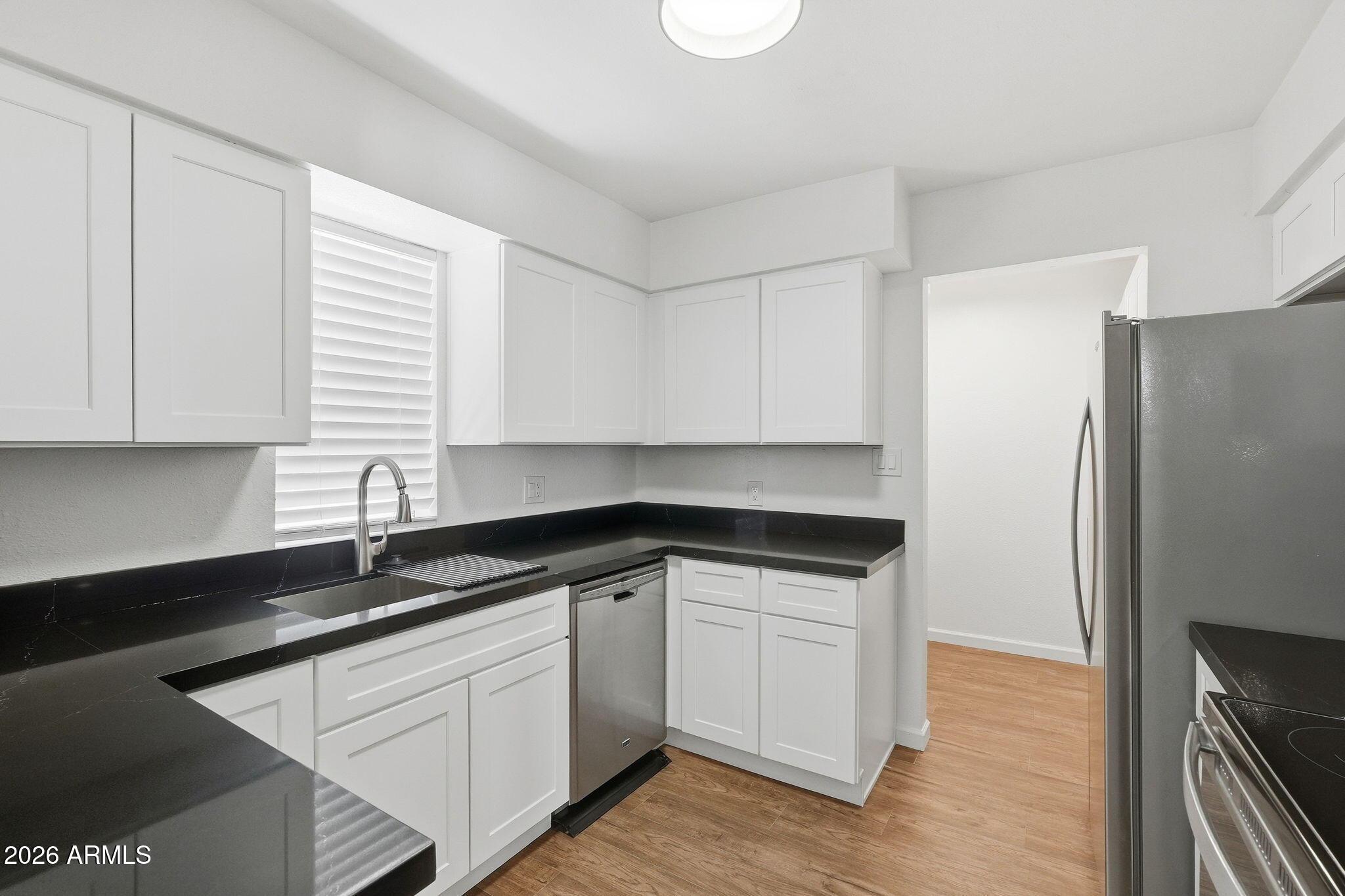 a kitchen with granite countertop white cabinets and white appliances