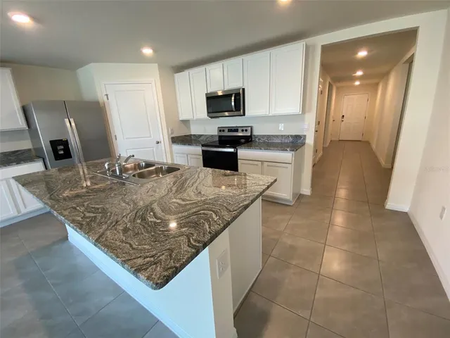 a kitchen with white cabinets and black appliances
