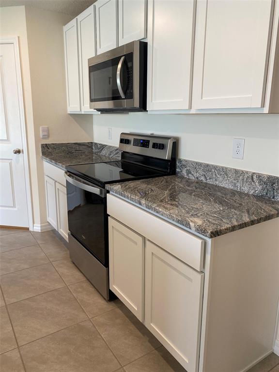 4961 Southwest 88th Place Ocala, FL 34476 - Photo 22 of 50 a kitchen with stainless steel appliances granite countertop a sink stove and microwave