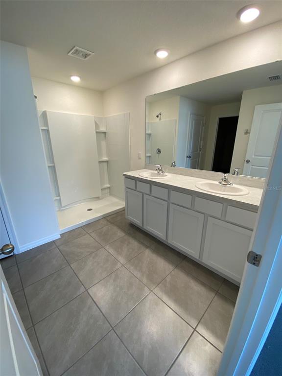4961 Southwest 88th Place Ocala, FL 34476 - Photo 31 of 50 a large bathroom with a large mirror vanity and shower