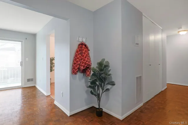 a view of a room with wooden floor and a potted plant