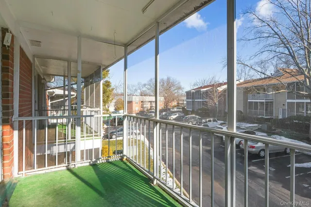 a view of a balcony with floor to ceiling windows and wooden fence