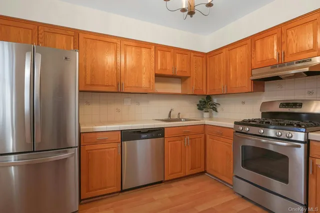 a kitchen with stainless steel appliances granite countertop a refrigerator sink stove and cabinets