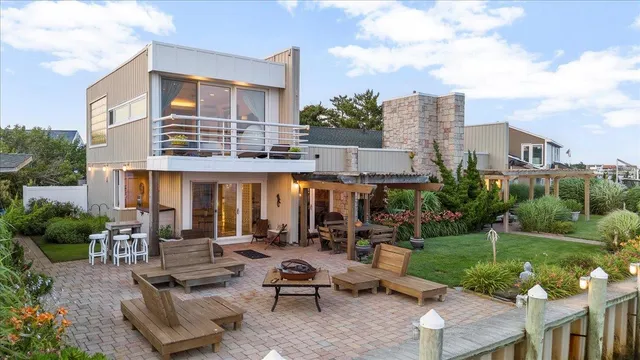 a view of a patio with couches table and chairs with garden and plants