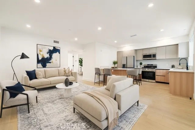 a living room with furniture and kitchen view