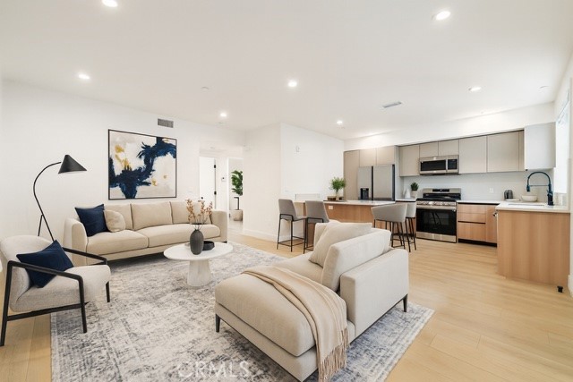 a living room with furniture and kitchen view
