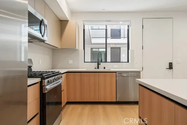 a kitchen with stainless steel appliances a stove a sink and a microwave