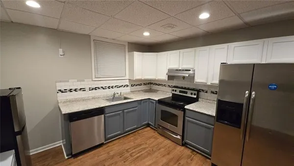 a kitchen with stainless steel appliances granite countertop a refrigerator stove and sink