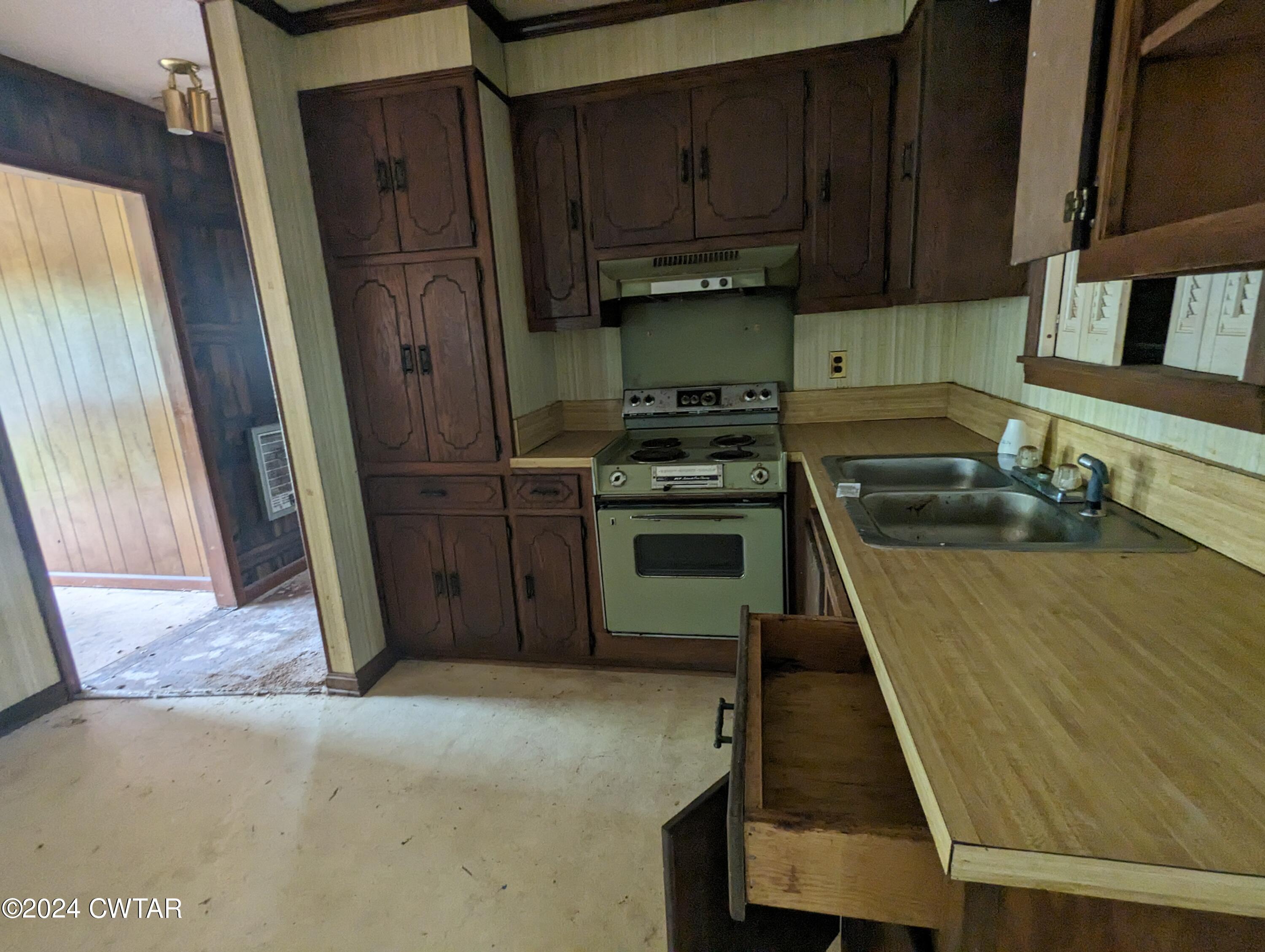 650 Old Finger Road Henderson, TN 38340 - Photo 6 of 19 a kitchen with wooden cabinets and a stove top oven