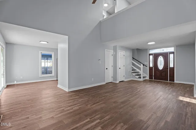 a living room with furniture a clock on wall and a window