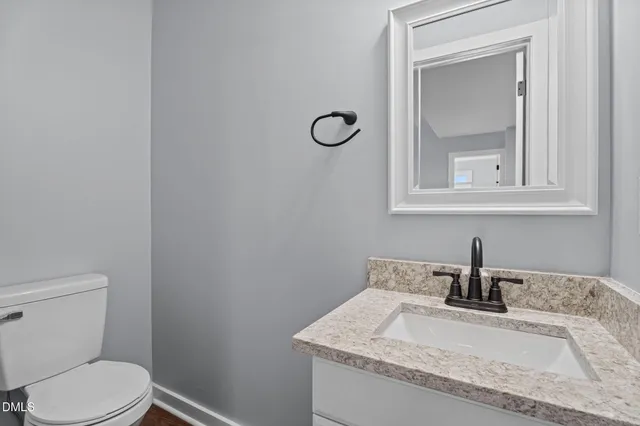 a view of a refrigerator in kitchen and an empty room with wooden floor and a window