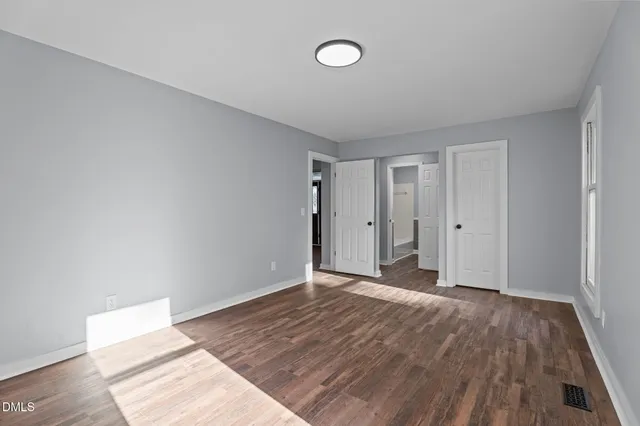 a bedroom with a bed table chair and a potted plant
