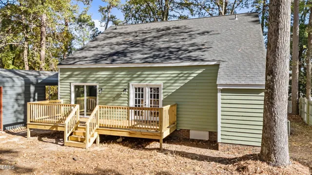 a view of a house with a yard and wooden fence
