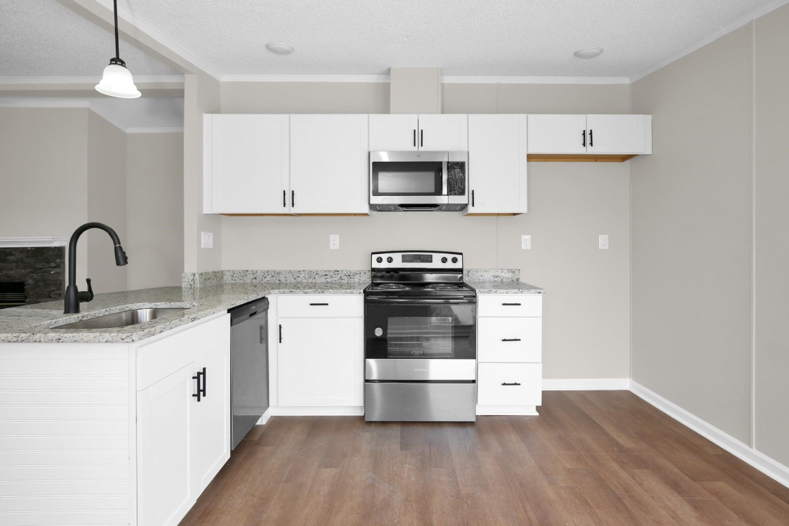 1357 Heritage Way Cameron, NC 28326 - Photo 12 of 28 a kitchen with stainless steel appliances granite countertop a sink stove and white cabinets with wooden floor