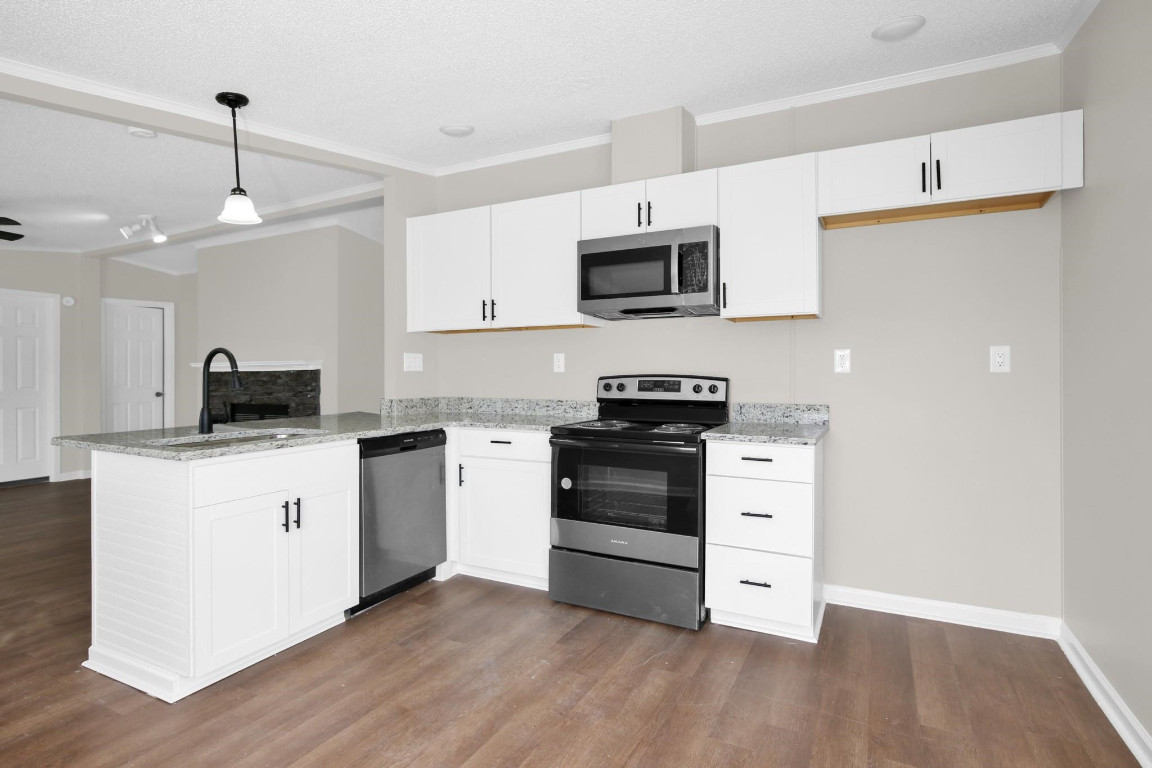 1357 Heritage Way Cameron, NC 28326 - Photo 13 of 28 a kitchen with stainless steel appliances a white stove top oven cabinets and a wooden floor