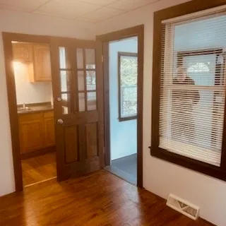 an empty room with wooden floor and windows