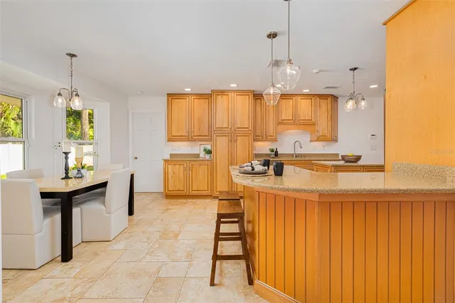 a large kitchen with kitchen island granite countertop a sink and a refrigerator