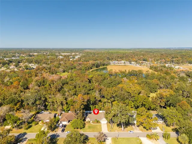an aerial view of house with yard and mountain view in back