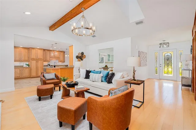 a living room with furniture kitchen view and a large window