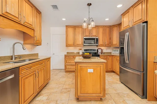 a kitchen with stainless steel appliances a refrigerator sink and cabinets