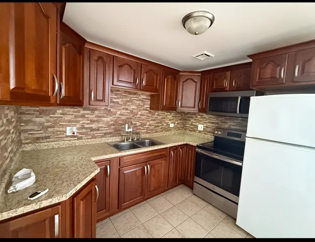 a kitchen with granite countertop stainless steel appliances and cabinets