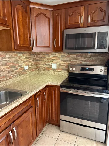 a kitchen with stainless steel appliances granite countertop wooden cabinets a sink and dishwasher