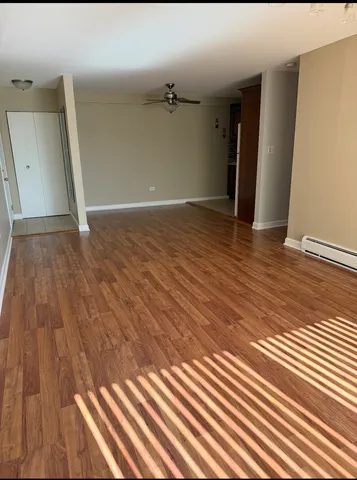 a view of a room with wooden floor and ceiling fan